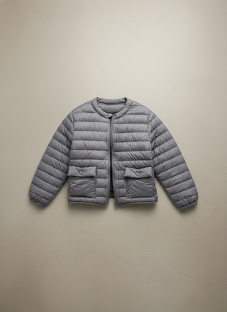 Gray puffer jacket on a beige background